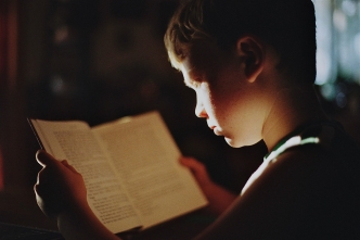 Een jongen die een boek leest